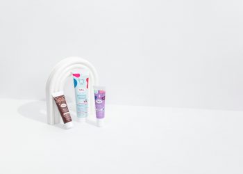 three tubes of toothpaste and a tube of toothpaste on a white