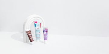 three tubes of toothpaste and a tube of toothpaste on a white