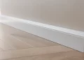 Poser des plinthes en MDF peintes après un parquet : coupe, collage et finition invisible